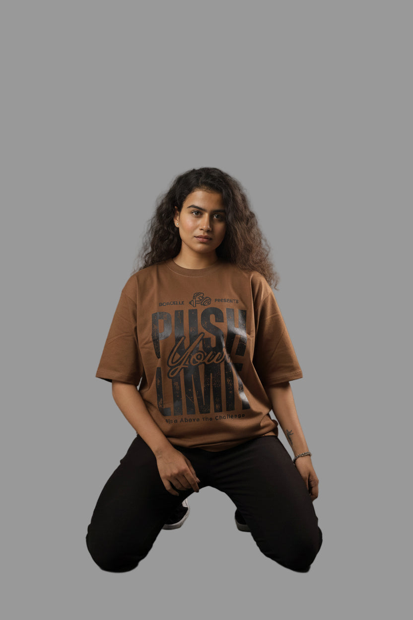 Woman wearing a brown t-shirt with text, kneeling on a plain background